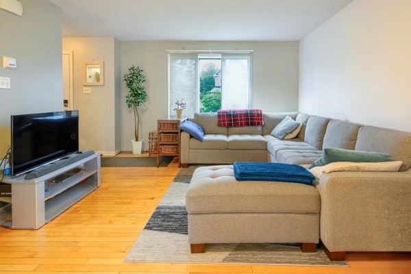 Living room with a large grey sectional sofa, ottoman, and television on a media console. - 237 Rue De L'atmosphère, Gatineau