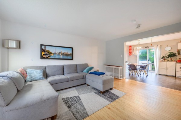 Living room with sectional sofa, rug, and view into dining area and kitchen. - 237 Rue De L'atmosphère, Gatineau