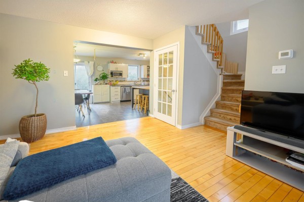 Living room showing view into kitchen and dining area, with staircase to the right. - 237 Rue De L'atmosphère, Gatineau