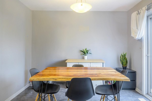 Dining room with a wooden table, black chairs, and a console table against the wall. - 237 Rue De L'atmosphère, Gatineau