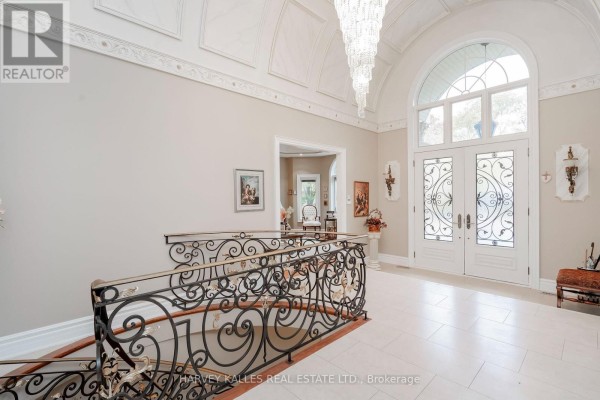 View of the foyer showing double doors, chandelier, and artwork on the walls. - 2370 Hammond Road, Mississauga