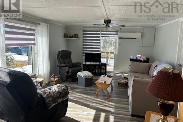 Living room with two sofas, a recliner, coffee table, and large windows with blinds. - 2379 Upper Clyde Road, Clyde River
