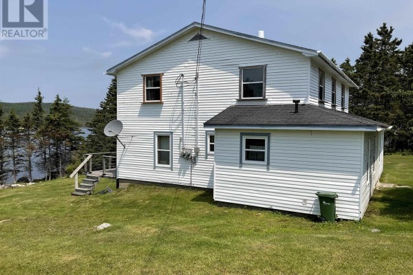 Rear exterior of a white clapboard house with water and trees visible. - 238 Cole Harbour Village Road, Cole Harbour