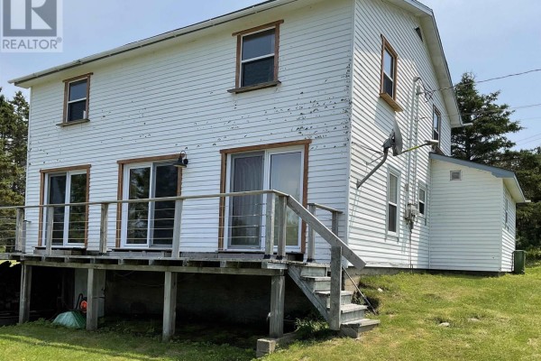 Rear deck with sliding glass doors on a white clapboard house with wooden stairs. - 238 Cole Harbour Village Road, Cole Harbour