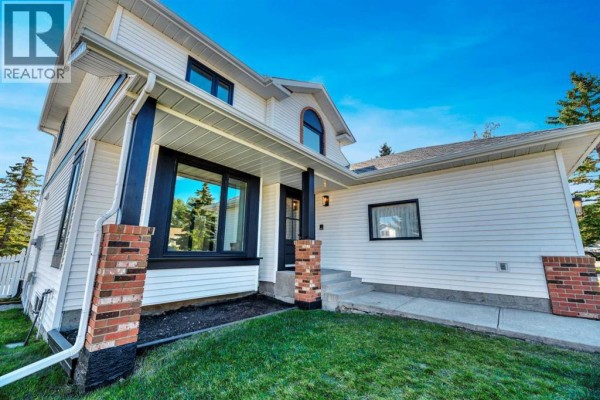 Kitchen with wooden cabinets, white countertops, and bay window seating area - 238 Hawktree Bay Nw, Calgary