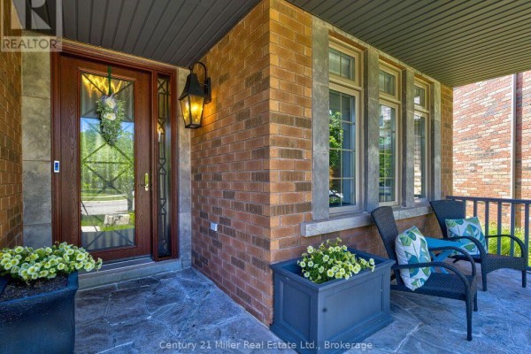 Close-up of the front door with decorative glass, surrounded by brick. - 2380 Gladacres Lane, Oakville