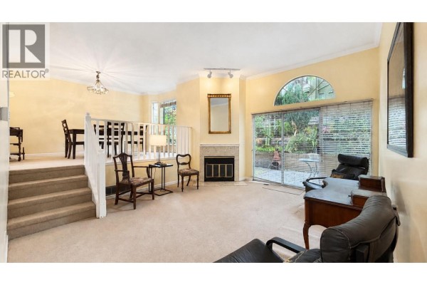 Living room with a staircase leading to dining area, desk, and view of the main entrance. - 2387 Quayside Court, Vancouver
