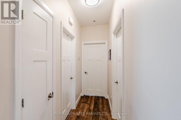Hallway with white doors and wood-look flooring - 2389 Watson Crescent Cornwall