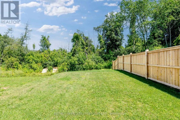 Grassy backyard with new wooden fence and trees - 2389 Watson Crescent Cornwall