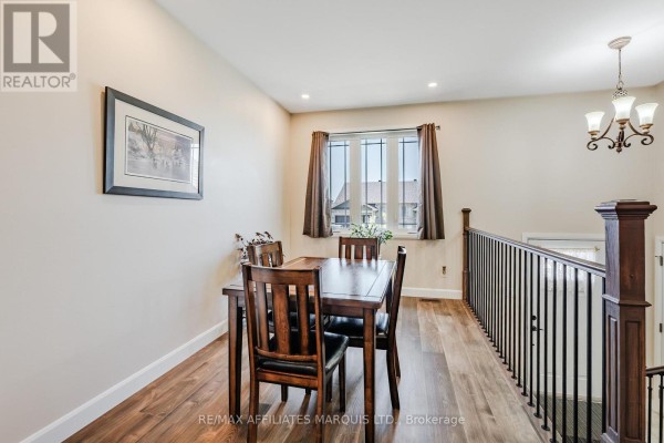 Dining room with wooden table and chairs, chandelier, and decorative window - 2389 Watson Crescent Cornwall