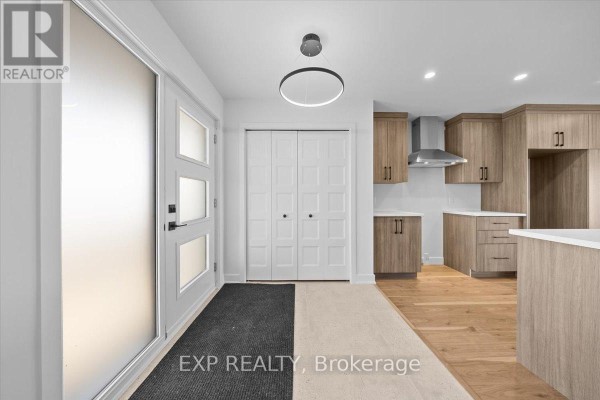 Foyer features white walls, a frosted glass front door, and leads to the kitchen area. - 239 Carpe Street, Casselman