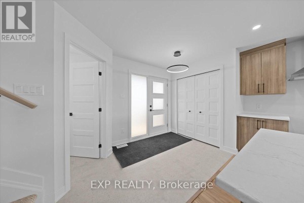 Powder room with a vanity, toilet, and a long horizontal window overlooking the blue sky. - 239 Carpe Street, Casselman