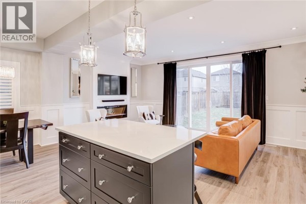Open concept living room with kitchen island, fireplace, TV and sofa - 239 Cranbrook Street Kitchener