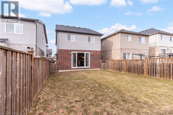 Backyard with wooden fence and sliding glass doors - 239 Cranbrook Street Kitchener