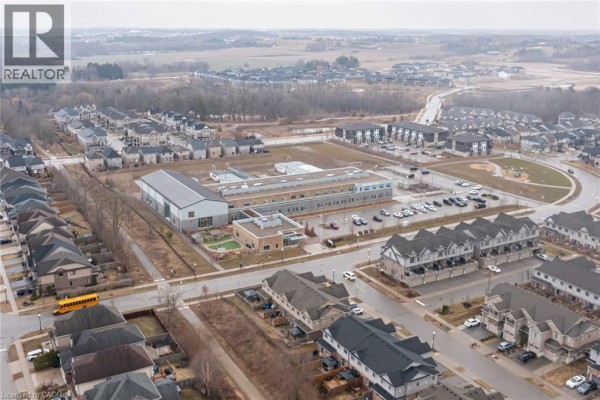 Aerial view of suburban neighborhood with school, townhouses, playground, and parking lot - 239 Cranbrook Street Kitchener