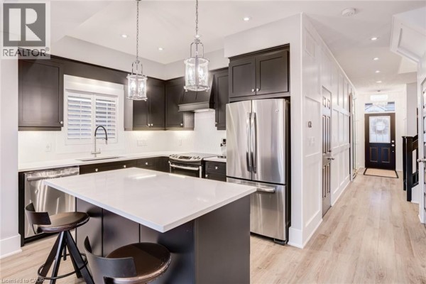 Modern kitchen with dark cabinets, quartz island, and stainless steel appliances - 239 Cranbrook Street Kitchener