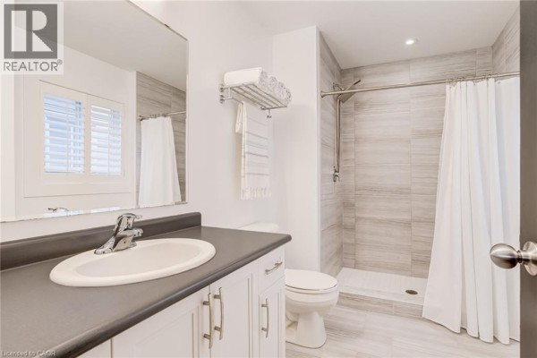 Modern bathroom vanity, sink, toilet, and tiled shower - 239 Cranbrook Street Kitchener