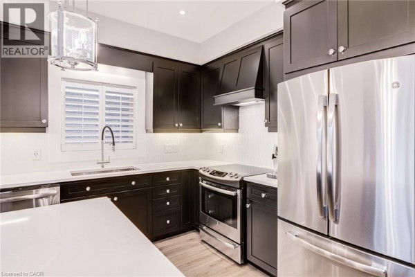 Modern kitchen with dark cabinets, quartz counters, and stainless steel appliances - 239 Cranbrook Street Kitchener