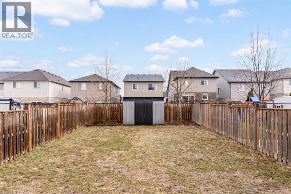 Fenced backyard with shed, lawn, basketball hoop, and playset - 239 Cranbrook Street Kitchener