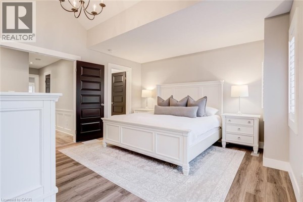 Bedroom with vaulted ceiling, king bed, and dark wood doors - 239 Cranbrook Street Kitchener