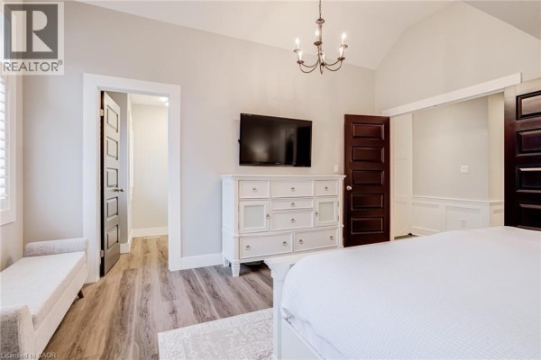 Bedroom with vaulted ceiling, TV, white dresser & dark doors - 239 Cranbrook Street Kitchener