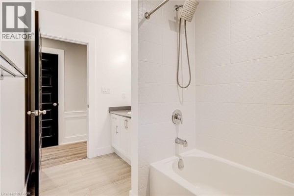 Modern bathroom with bathtub, shower, vanity, and black door - 239 Cranbrook Street Kitchener
