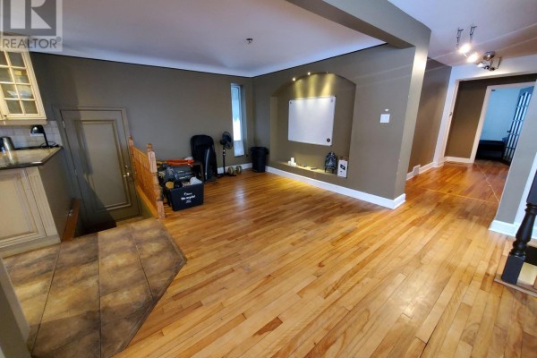 Open concept living area with hardwood floors and a staircase leading down. - 239 Dale Avenue, Ottawa