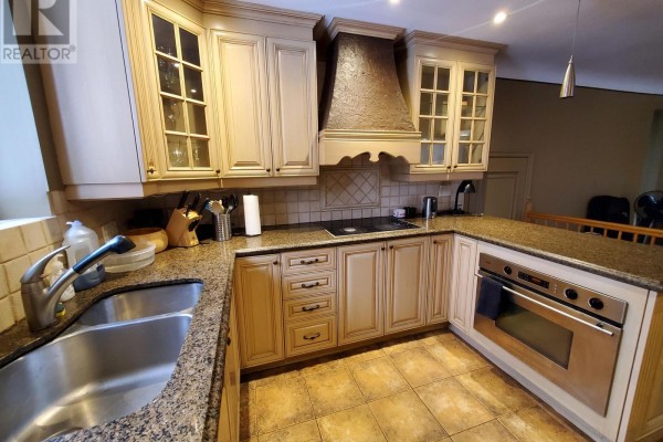 Corner kitchen with light wood cabinets, granite countertops, stainless steel oven, and double sink. - 239 Dale Avenue, Ottawa