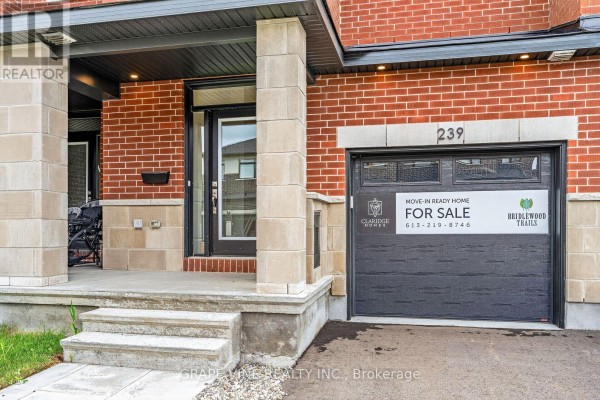 Close-up of the townhouse entrance at 239 Monticello Avenue with stairs and garage. - 239 Monticello Avenue, Ottawa