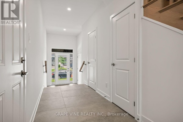 Interior front foyer with light grey tile floor, white walls, and doors. - 239 Monticello Avenue, Ottawa