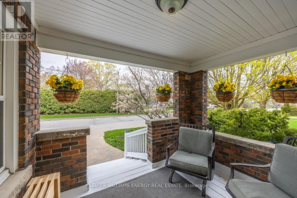 View from the covered front porch overlooking the street with hanging flower baskets. - 239 Perry Street, Scugog