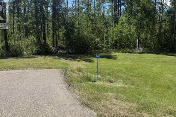 A blue sign numbered 16 is in a grassy area with trees behind. - 24, 2404 394 Township, Rural Lacombe County