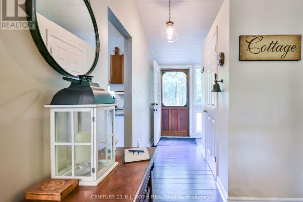 Large wooden dining table and chairs with vaulted ceilings and a view into the living room. - 24 - 1213 Camp Jackson Road, Muskoka Lakes