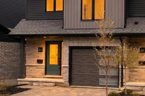 Exterior of townhouse entrance and garage illuminated at dusk with warm interior lights. - 24 - 2261 Linkway Boulevard, London South