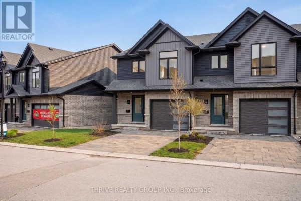 Row of modern townhouses with dark grey siding, brick bases, and paved driveways. - 24 - 2261 Linkway Boulevard, London South
