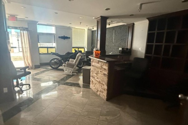 Reception area with marble tile floor, desk, chairs, and motorcycle. - 24 - 6033 Shawson Drive, Mississauga