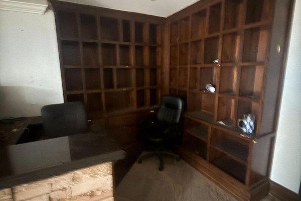 Office with dark wood built-in shelves, desk, and black leather chair. - 24 - 6033 Shawson Drive, Mississauga
