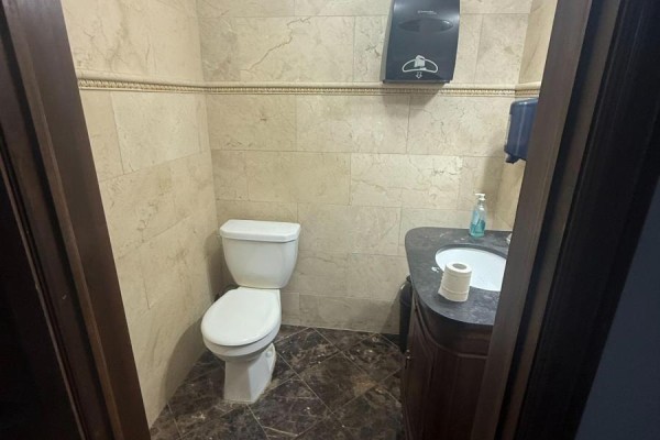 Powder room with toilet, sink, and light-colored tiled walls. - 24 - 6033 Shawson Drive, Mississauga