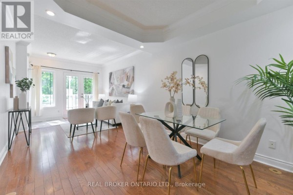 Dining area with glass table, chairs, and view of living room beyond. - 24 - 70 Byng Avenue, Toronto