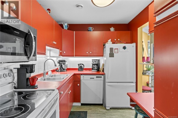 Kitchen with red cabinets, white appliances, a double sink, and a stainless steel microwave. - 24 450 Bay Ave, Parksville