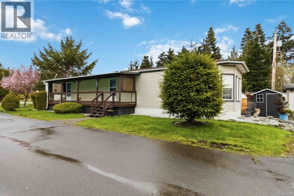Exterior view of mobile home with porch and landscaped yard - 24 7021 Grant Rd W, Sooke