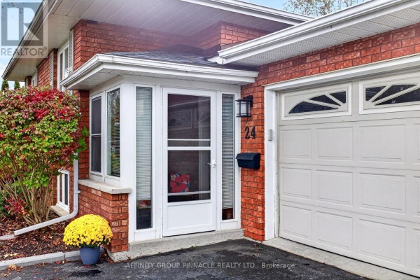 Close-up of the home entrance with a white door, glass panels, and garage. - 24 Andrew Drive, Kawartha Lakes