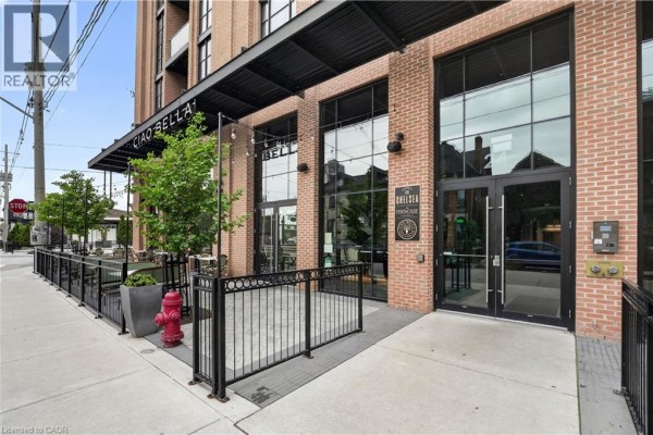 Ground floor entrance to the building with large glass doors and outdoor seating. - 24 Augusta Street Unit# 302, Hamilton