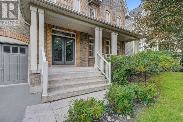 Close-up of the covered porch with stairs leading to double entry doors and lush greenery. - 24 Bellhouse Place, Whitby