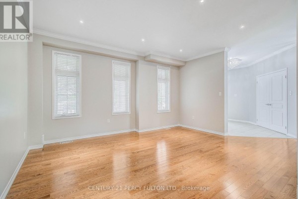 Living room with hardwood floors, large windows, and a view of the foyer. - 24 Bellhouse Place, Whitby