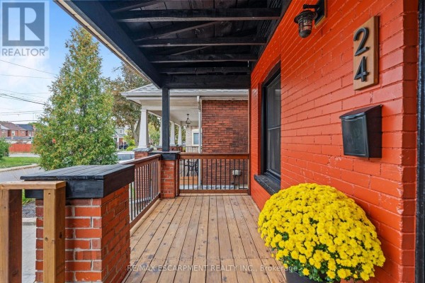 Wooden porch with black railings and ceiling, leading to a red brick house entrance. - 24 Belview Avenue, Hamilton