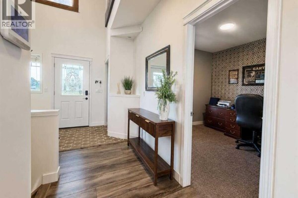 Living room with a large sectional sofa, coffee table, entertainment unit, and decorative pillows. - 24 Brander Avenue Nw, Langdon