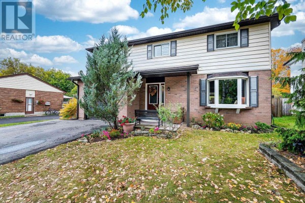 Close-up of the front entrance with a red door, bay window, and brick exterior. - 24 Carberry Road Street, Erin