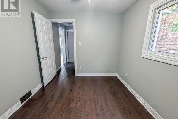 Bedroom with hardwood floors, ceiling fan, and window view - 24 Churchill Street St Catharines