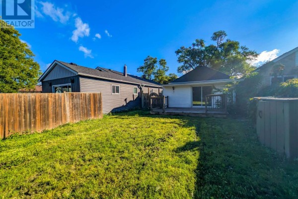 Backyard with wooden fence, deck, and lawn - 24 Churchill Street St  Catharines